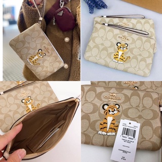 🎀 คล้องมือ ลายเสือ size 1L COACH C7698 LARGE CORNER ZIP WRISTLET IN SIGNATURE CANVAS WITH TIGER