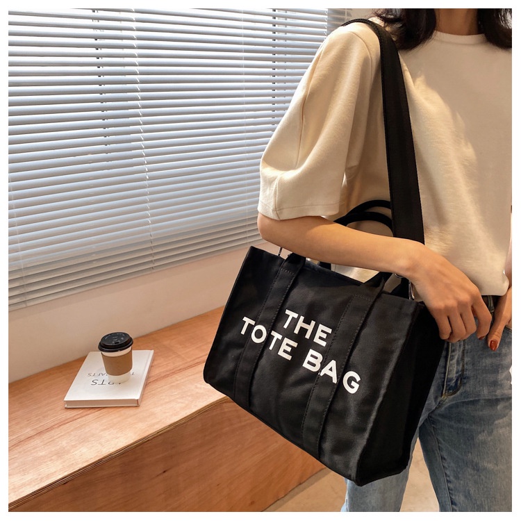 ภาพหน้าปกสินค้าTHE TOTE BAG กระเป๋าถือผ้าแคนวาส กระเป๋าตั้งเป็นทรง พร้อมสายสะพายยาว สินค้าพร้อมส่งค่ะ จากร้าน queen_ppp บน Shopee