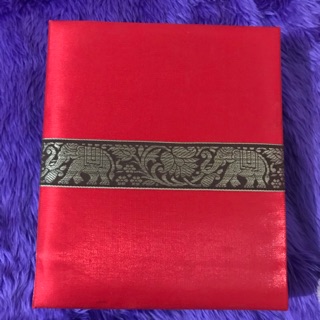 กล่องผ้าไหมสีแดงคาดกลางด้วยลายช้างทอง ตัวกล่องด้านบนบุด้วยสำลีทำให้กล่องด้านบนมีลักษณะนิ่ม