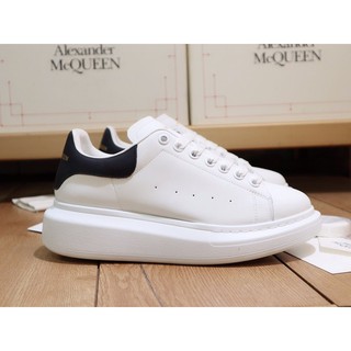 ภาพหน้าปกสินค้าAlexander McQueen รองเท้าผ้าใบ สีดําและสีขาว ที่เกี่ยวข้อง