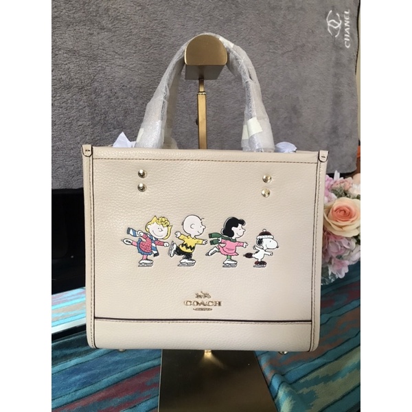 พร้อมส่งแท้-coach-x-peanuts-dempsey-tote-22-with-snoopy-and-friends-motif-สีขาวครีม