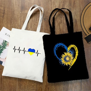 กระเป๋าช้อปปิ้ง ผ้าแคนวาส พิมพ์ลายธงชาติยูเครน ดอกทานตะวัน จุของได้เยอะ สไตล์วินเทจ แฟชั่น สําหรับคู่รัก HW9N